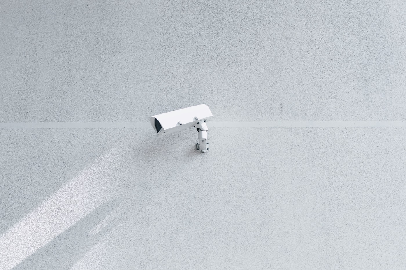 Wall-mounted security camera representing a fixed wired installation